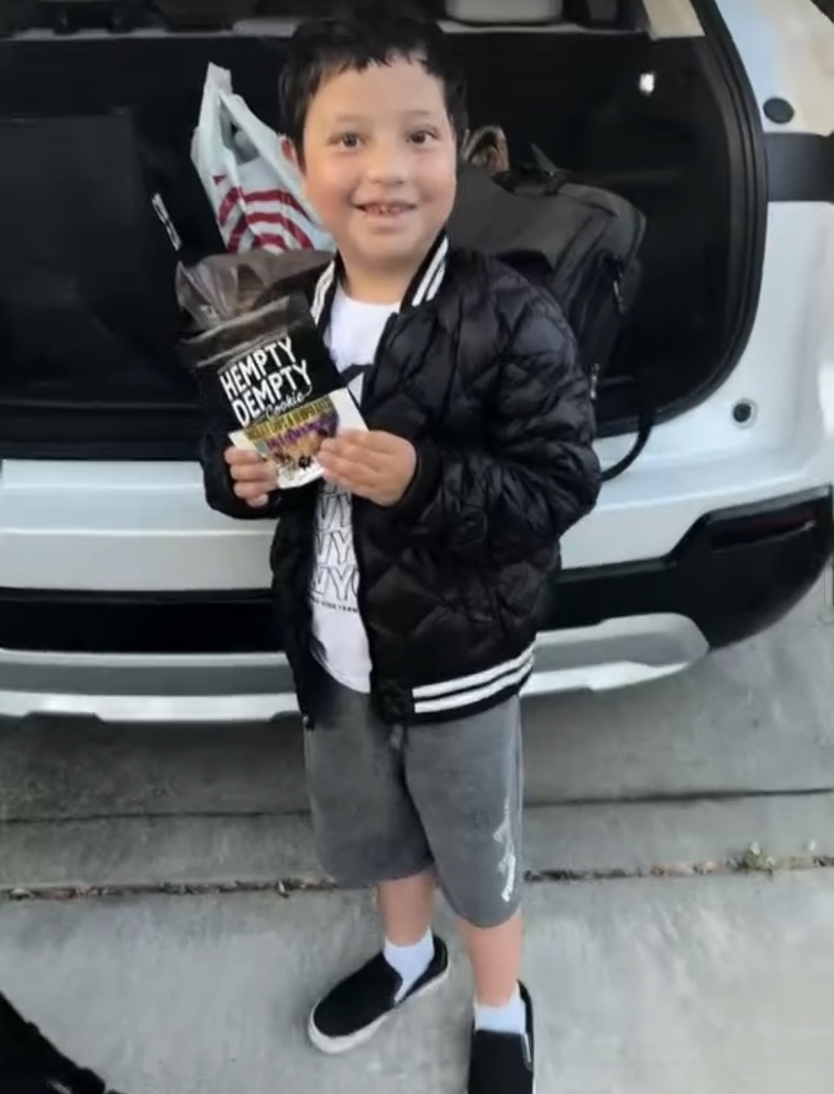 Kid smiling holding Hempty Dempty cookie