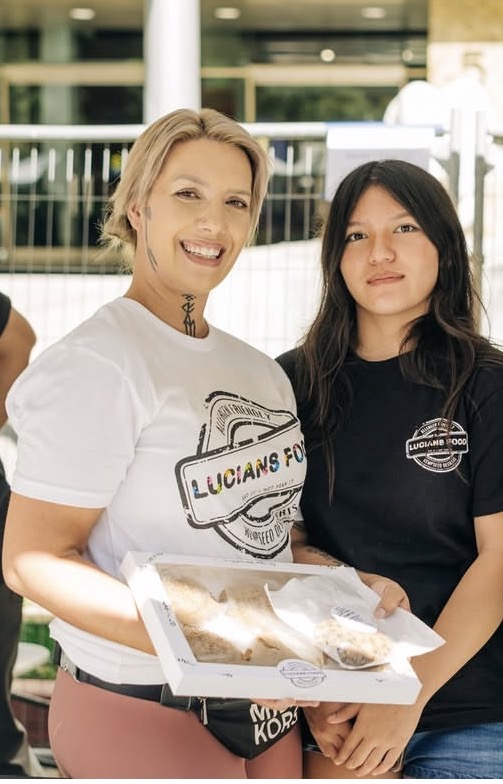 Lucian's Food team members sharing allergen-free cookies at a community market